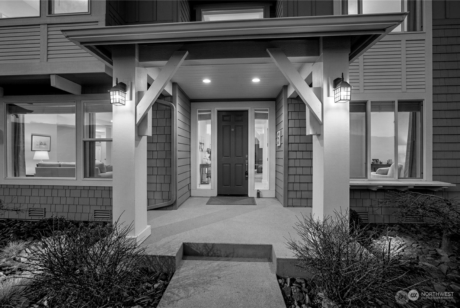 Premium twilight photograph of the home with warm interior glow and deep sky